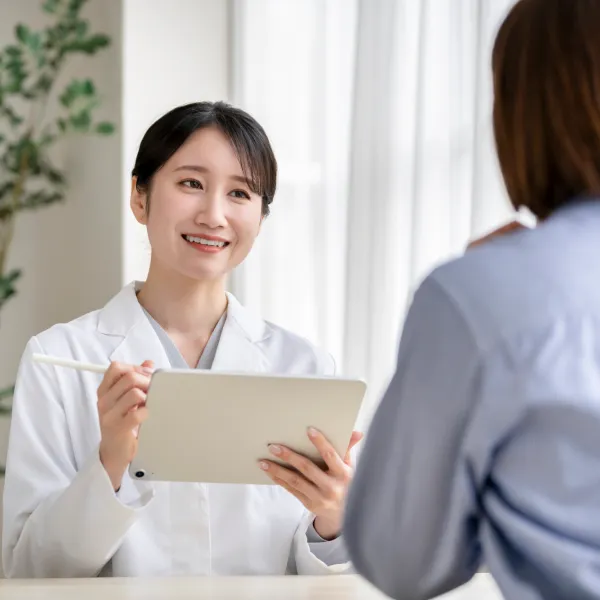 白衣のスタッフが対面で相談に応じる様子